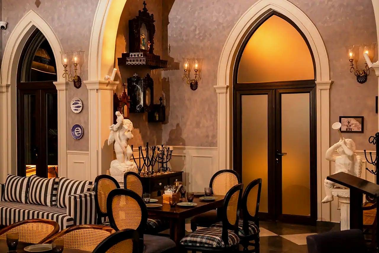 An arched lounge with striped sofas and low tables