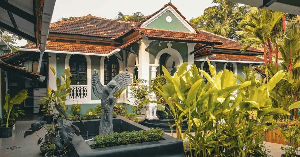 The bungalow's tiled roof and verandah seen across the courtyard garden