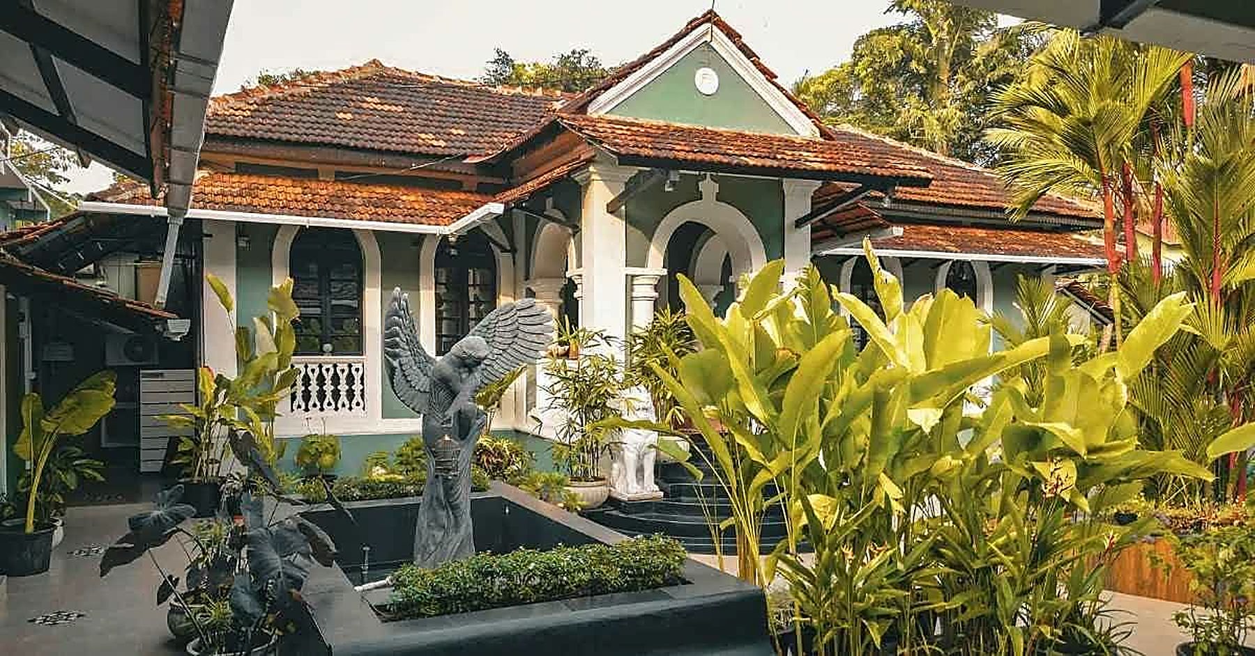 The bungalow's tiled roof and verandah across the courtyard garden